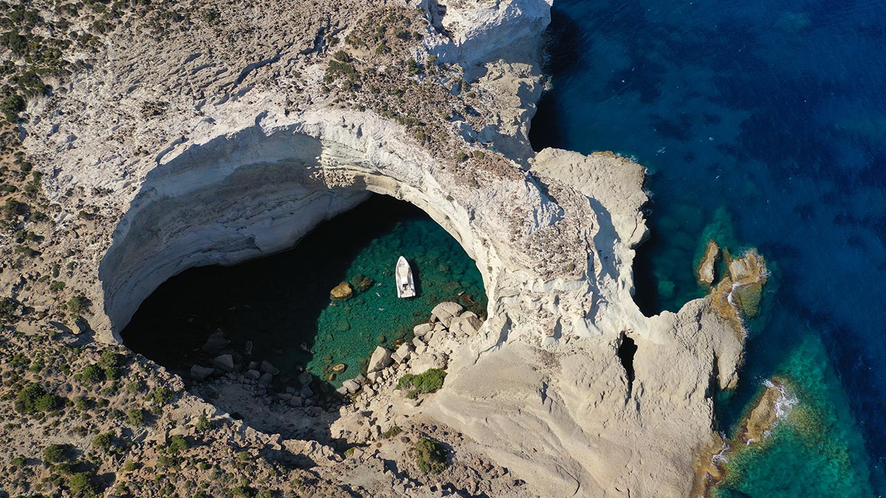 Aerial view of Sykia Cave accessible by boat in Milos