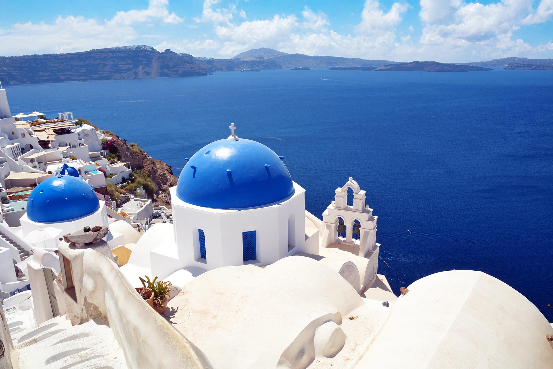 Santorini caldera view with blue dome church overlooking the Aegean Sea in Greece